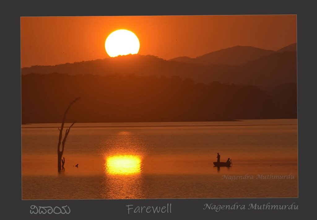 Golden sunset over still water, a silhouetted boat and distant hills.